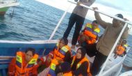 Survivors sit on wooden boat while being rescued, after a boat with 43 people on board capsized off Sulawesi island in Takalar regency, South Sulawesi province, Indonesia. Antara Foto/National Search and Rescue Agency/ via Reuters
