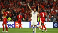 Real Madrid's Karim Benzema celebrates after winning the Champions League as Liverpool players look dejected REUTERS/Kai Pfaffenbach
