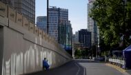 A worker in a protective suit rests on a street as the city prepares to end the lockdown placed to curb the coronavirus disease (COVID-19) outbreak in Shanghai, China May 31, 2022. REUTERS/Aly Song