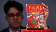 Rare Books Specialist and curator Mark Wiltshire poses with a rare first edition and signed by the author copy of 'Harry Potter and the Philosophers Stone' by British author J.K. Rowling. Reuters/Henry Nicholls