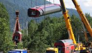Carriages of a derailed regional train in which five people were killed and dozens injured are lifted onto trucks in Burgrain near the Bavarian town of Garmisch-Partenkirchen, Germany, June 6, 2022. Vifogra/Goppelt via REUTERS


