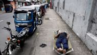 A man sleeps on a folding bed on a pavement as he waits in queue to buy petrol due to fuel shortage, amid the country's economic crisis, in Colombo, Sri Lanka on June 17, 2022. (REUTERS/Dinuka Liyanawatte/FILE PHOTO)