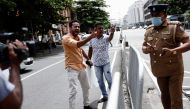 Demonstrators who blocked a main road with their vehicle to demand fuel near President Gotabaya Rajapaksa's residence, argue with a police officer in Colombo, Sri Lanka, June 29, 2022. Reuters/Dinuka Liyanawatte