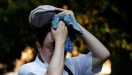 A man wipes off sweat with a towel at a park under the strain of Tokyo's hottest June streak since 1875 in Tokyo, Japan, June 30, 2022. REUTERS/Kim Kyung-Hoon


