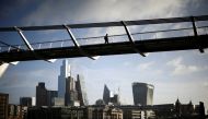 The City of London financial district is seen as people walk over Millennium Bridge in London, Britain, February 16, 2022. REUTERS/Henry Nicholls/File Photo

