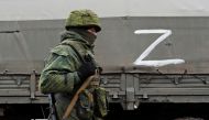 A serviceman of pro-Russian militia walks nest to a military convoy of armed forces of the separatist self-proclaimed Luhansk People's Republic (LNR) on a road in the Luhansk region, Ukraine February 27, 2022. REUTERS/Alexander Ermochenko