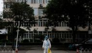 Medical worker in a protective suit crosses a street following a coronavirus disease (COVID-19) outbreak in Beijing, China, July 6, 2022. REUTERS/Thomas Peter
