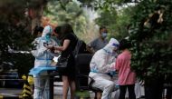 Medical workers register people at a nucleic acid testing station, following a coronavirus disease (COVID-19) outbreak, in Beijing, China, July 6, 2022. REUTERS/Thomas Peter