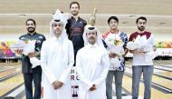 The podium winners of the H H The Amir’s Cup Bowling Championship with officials during the presentation ceremony.
