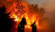 Firefighters try to extinguish a wildfire in Ntrafi, Athens, Greece, July 19, 2022. (REUTERS/Costas Baltas)