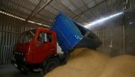 A driver unloads a truck at a grain store during barley harvesting in the village of Zhovtneve, Ukraine, July 14, 2016. REUTERS/Valentyn Ogirenko

