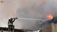 A firefighter works to douse a fire in a building, as Russia's attack on Ukraine continues, in Mykolaiv, in this handout picture released on July 31, 2022. (Reuters)

