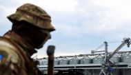 A Ukrainian serviceman stands in front of silos of grain from Odesa Black Sea port, before the shipment of grain as the government of Ukraine awaits signal from UN and Turkey to start grain shipments, amid Russia's invasion of Ukraine, in Odesa, Ukraine July 29, 2022. REUTERS/Nacho Doce
