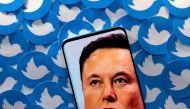An image of Elon Musk is seen on smartphone placed on printed Twitter logos in this picture illustration. (Reuters/Dado Ruvic/Illustration/File Photo)