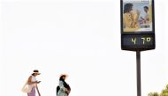File Photo: Women walk next to a thermometer displaying 47 Celsius degrees (116.6 Fahrenheit degrees) during the first heatwave of the year in Seville, Spain, on June 11, 2022. (REUTERS/Marcelo del Pozo)