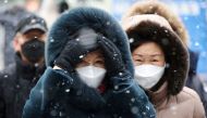 File Photo: Commuters walk during snowfall, amid the coronavirus disease (COVID-19) pandemic, in central Seoul, South Korea, January 17, 2022. REUTERS/Kim Hong-Ji