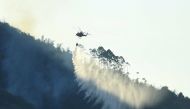 A helicopter works to put out wildfire in a forest, amid hot temperature in Chongqing, China August 19, 2022. cnsphoto via REUTERS