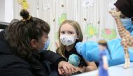 File Photo: Seven-year-old Lena Graveline-Roux has her hand held by her mother at a vaccination clinic after Canada approved Pfizer's COVID-19 vaccine for children aged 5 to 11, in Montreal, Quebec, Canada, November 26, 2021. (REUTERS/Christinne Muschi)