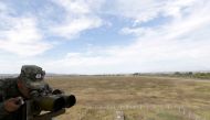 File Photo: An Albanian Military Force member uses binoculars in Kucova Air Base in Kucova, Albania, on October 3, 2018. (REUTERS/Florion Goga)
