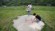 An instructor sets up landing sign as a trainee prepares to learn to fly an aerosol drone at LTFY drone training school on the outskirts of Beijing, China August 2, 2017. REUTERS/Jason Lee

