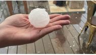 A person holds up a hailstone during a hailstorm in Girona, Spain August 30, 2022. Sicus Carbonell via Reuters 