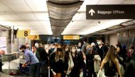 File Photo: Travelers wearing protective face masks to prevent the spread of the coronavirus disease reclaim their luggage at the airport in Denver, Colorado, US, November 24, 2020. (REUTERS/Kevin Mohatt)
