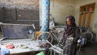 A woman reacts as she goes through her belongings, following rains and floods during the monsoon season in Nowshera, Pakistan, on September 1, 2022. REUTERS/Fayaz Aziz