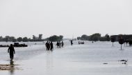 People walk amid rising flood waters on the Indus highway, following rains and floods during the monsoon season in Mehar, Pakistan August 31, 2022. REUTERS/Akhtar Soomro