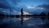 A man rides a unicycle on a bank of Huangpu River as Typhoon Hinnamnor approaches, following the coronavirus disease (COVID-19) outbreak, in Shanghai, China, September 3, 2022. REUTERS/Aly Song