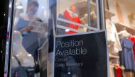 A sales assistant is seen through the window of a retail store displaying a job vacancy sign in central Sydney, Australia, December 5, 2016. Picture taken December 5, 2016. REUTERS/Steven Saphore

