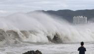 A man looks at a high wave caused by Typhoon Hinnamnor in Ulsan, South Korea, September 6, 2022. 
