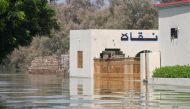 A man stands at the main entrance of a building amid floodwater in village Arazi, in Sehwan, Pakistan September 11, 2022. Reuters/Yasir Rajput 
