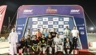 Qatar Motor and Motorcycle Federation's Secretary General Abdul Razzaq Al Kuwari with the podium winners at the end of the third round on Friday.