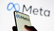 Woman holds smartphone with Meta logo in front of a displayed Facebook's new rebrand logo Meta in this illustration picture taken on October 28, 2021. File Photo / Reuters
