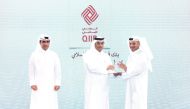 Minister of Labour H E Dr. Ali bin Smaikh Al Marri presents the award to Ali Hamad Al Musaifri, Head of the Human Resources and Administrative Affairs Sector at QIIB, during the ceremony in Doha, recently. 