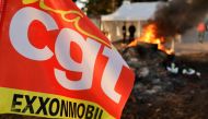 CGT trade union flag flutters as fire burns in front of the ExxonMobil oil refinery in Port-Jerome-sur-Seine, France, October 12, 2022. Reuters/Pascal Rossignol
 