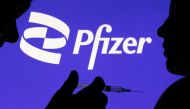 People pose with syringe with needle in front of displayed Pfizer logo in this illustration taken, on December 11, 2021. File Photo / Reuters
