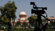 Members of media speak in front of cameras after a panel of the Supreme Court said it was divided on a decision to allow hijabs in classrooms, outside the premises of the court in New Delhi, India, October 13, 2022. (REUTERS/Anushree Fadnavis)