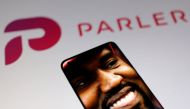 American rapper Kanye West's picture is seen on a smartphone in front of the logo of social media app Parler in this Illustration taken October 17, 2022. (REUTERS/Dado Ruvic)