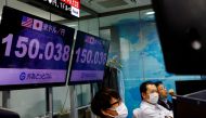 Employees of the foreign exchange trading company Gaitame.com react as they watch the Japanese yen exchange rate against the U.S. dollar at its dealing room in Tokyo