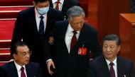 Former Chinese president Hu Jintao leaves his seat next to Chinese President Xi Jinping and Premier Li Keqiang at the Great Hall of the People in Beijing, China October 22, 2022. Reuters/Tingshu Wang