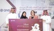 QNB officials award the last winner of the Triple your Salary campaign, in Doha, recently. 