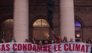 Activists of 'Les Amis de la Terre' and 'Alternatiba' collectives participate in an action against the Climate Finance Day event in Paris on October 27, 2022. (Photo by Geoffroy VAN DER HASSELT / AFP)