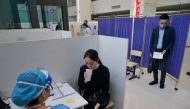 A resident takes an inhaled COVID-19 vaccine as a booster dose at a hospital in Shanghai, China October 26, 2022. China Daily via REUTERS/File Photo