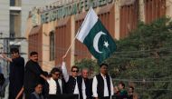 Pakistan's former prime minister Imran Khan waves the national flag during what they call 'a true freedom march', to pressure the government to announce new elections, in Lahore, Pakistan, October 28, 2022. (REUTERS/Akhtar Soomro)