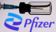 A vial and a syringe are seen in front of a displayed Pfizer logo in this illustration taken November 27, 2021. (REUTERS/Dado Ruvic)