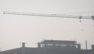 A labourer sits on top of an under-construction building on a smoggy morning in New Delhi, India November 2, 2022. REUTERS/Adnan Abidi