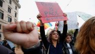 A woman holds a banner reading 