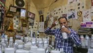 Syrian perfumer Mohammad al-Masri works at his shop in a historic souq of Damascus's old city on October 31, 2022. (AFP/Louai Beshara)
