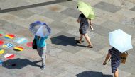 File photo: People shield themselves from the sun with umbrellas on a hot summer day in Cologne, Germany. (REUTERS/Thilo Schmuelgen)